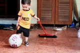 Dziecko z piłką i miotłą